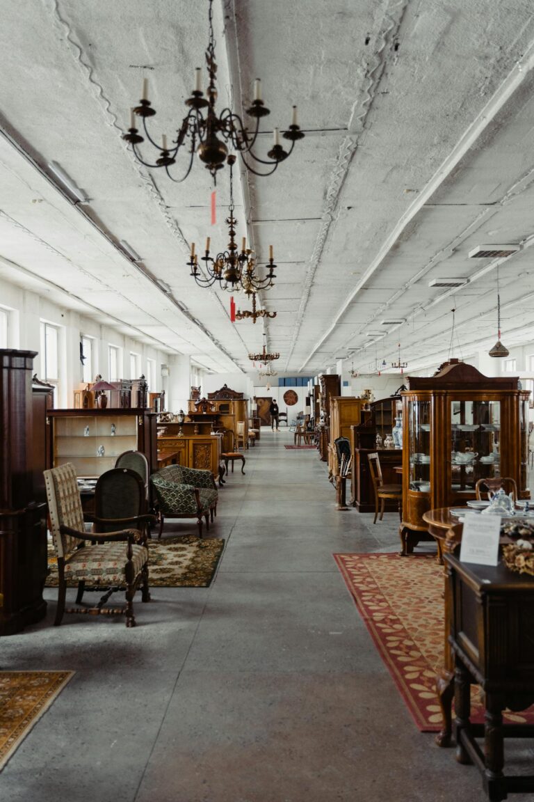 A long aisle in a vintage furniture store showcasing antique wooden pieces and chandeliers.
